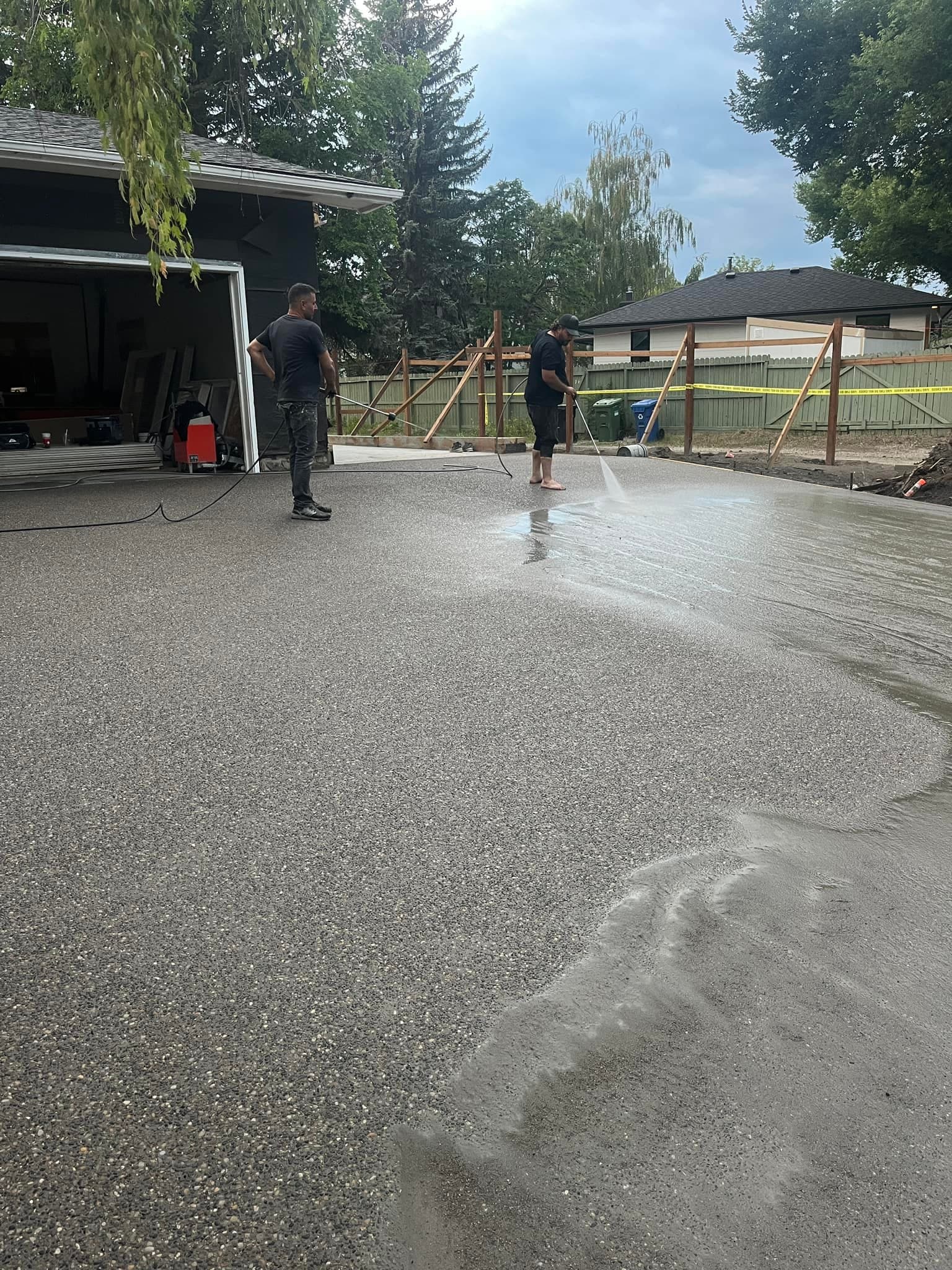 Pressure washing a newly installed concrete driveway